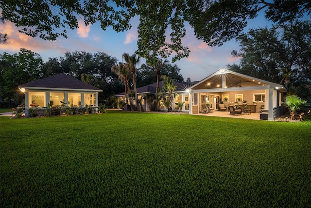 104 Smith Ln, League City, TX 77573 - back of property at dusk with a yard, an outdoor hangout area, and a patio