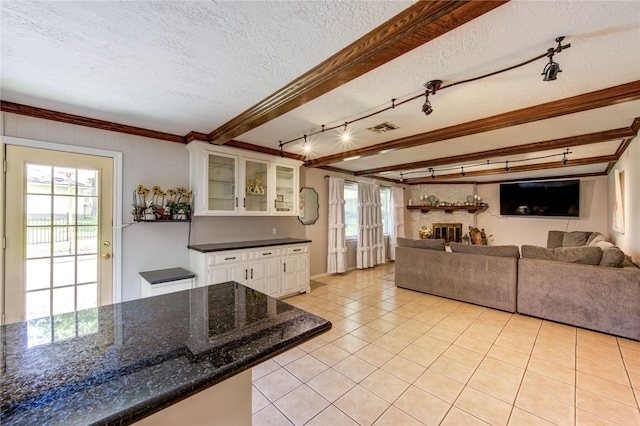 1223 Green Briar Dr, Huntsville, TX 77340 - living area featuring rail lighting, healthy amount of natural light, a brick fireplace, light tile patterned floors, and a textured ceiling