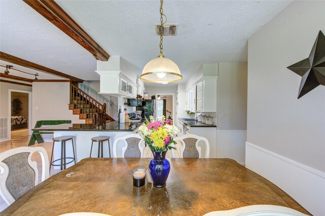 1223 Green Briar Dr, Huntsville, TX 77340 - dining area with stairs, wainscoting, beam ceiling, and a textured ceiling