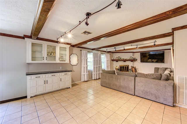 1223 Green Briar Dr, Huntsville, TX 77340 - living area with beam ceiling, a brick fireplace, crown molding, a textured ceiling, and baseboards