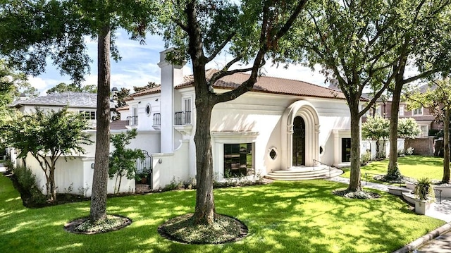 8618 Stable Crest Blvd, Houston, TX 77024 - mediterranean / spanish-style house with a front yard, stucco siding, a chimney, and a tiled roof