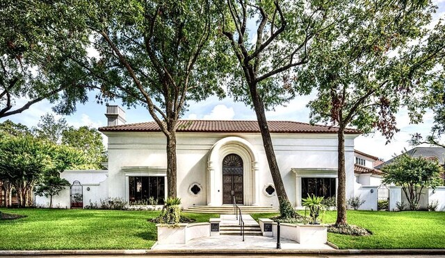 8618 Stable Crest Blvd, Houston, TX 77024 - back of house with a chimney, stucco siding, a yard, and a tile roof
