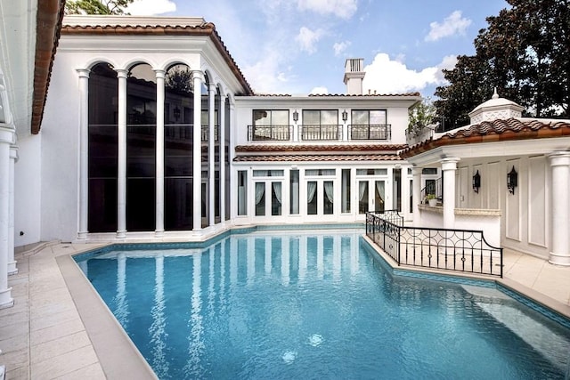 8618 Stable Crest Blvd, Houston, TX 77024 - rear view of house with a balcony, an outdoor pool, a patio area, and a chimney