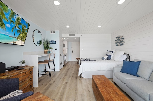 5220 Seawall Blvd Unit 1231, Galveston, TX 77551 - bedroom with recessed lighting, light wood-style floors, wood ceiling, and wood walls