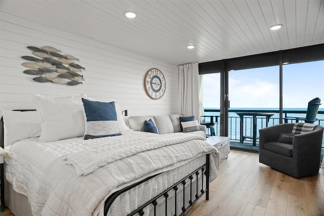 5220 Seawall Blvd Unit 1231, Galveston, TX 77551 - bedroom with expansive windows, access to exterior, wood walls, a water view, and multiple windows