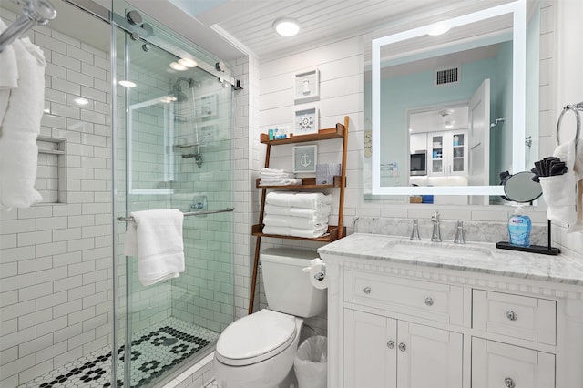 5220 Seawall Blvd Unit 1231, Galveston, TX 77551 - bathroom featuring tile walls, a stall shower, vanity, and toilet