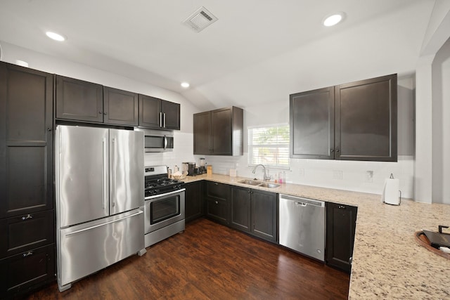 223 Adams St, Houston, TX 77011 - kitchen with stainless steel appliances, a sink, recessed lighting, vaulted ceiling, and decorative backsplash