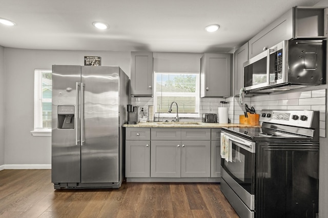 223 Adams St, Houston, TX 77011 - kitchen with stainless steel appliances, a sink, gray cabinets, tasteful backsplash, and recessed lighting