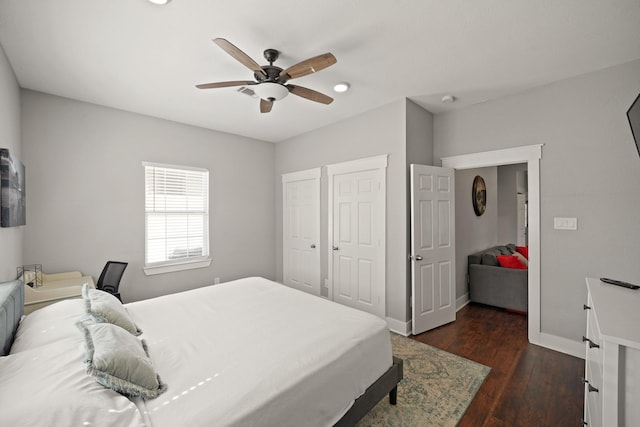 223 Adams St, Houston, TX 77011 - bedroom featuring baseboards, dark wood-style floors, ceiling fan, multiple closets, and recessed lighting