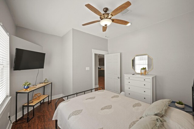 223 Adams St, Houston, TX 77011 - bedroom with dark wood-style floors, a ceiling fan, and baseboards