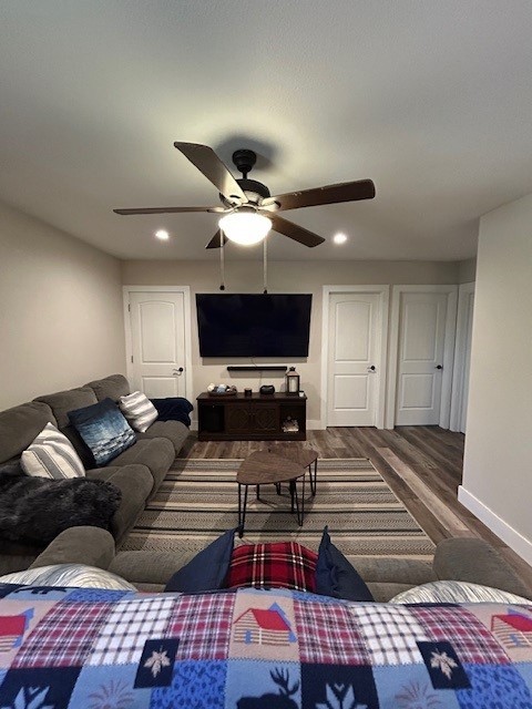 living area featuring wood finished floors, a ceiling fan, baseboards, and recessed lighting