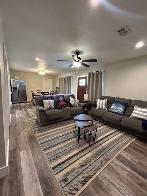 living area with wood finished floors and a ceiling fan