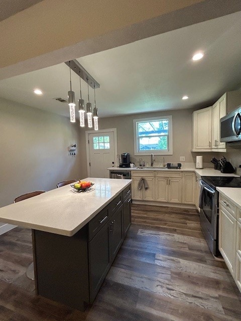 kitchen featuring stainless steel appliances, light countertops, recessed lighting, dark wood-style floors, and a kitchen island