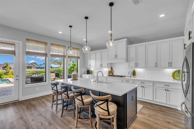 24906 Gingerbush Ln, Tomball, TX 77375 - kitchen with appliances with stainless steel finishes, light countertops, decorative backsplash, white cabinets, and a sink
