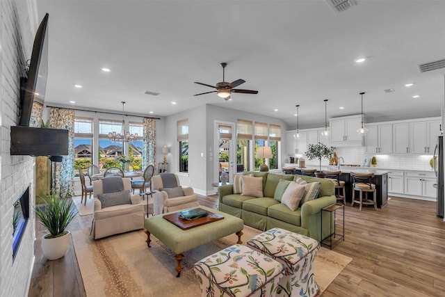 24906 Gingerbush Ln, Tomball, TX 77375 - living room featuring light wood finished floors, recessed lighting, a brick fireplace, a ceiling fan, and baseboards