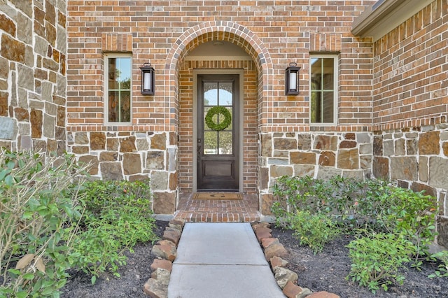 doorway to property with brick siding and stone siding