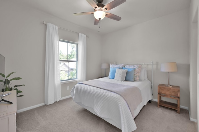 bedroom featuring light carpet, baseboards, and ceiling fan