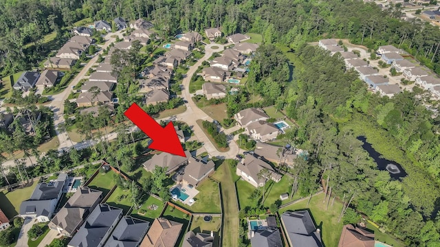 aerial overview of property's location featuring nearby suburban area and a heavily wooded area