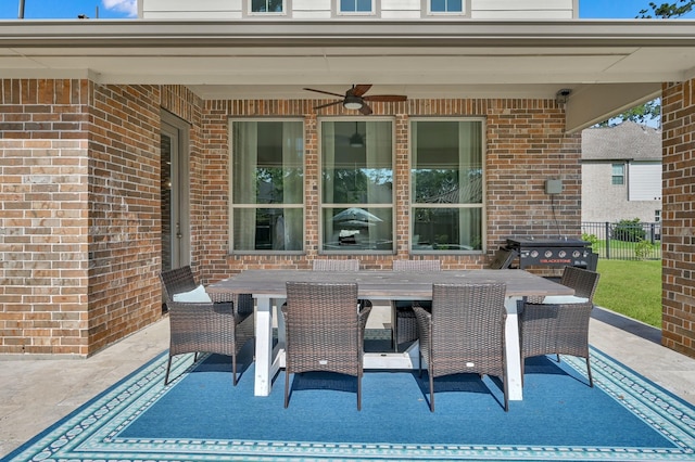 view of patio featuring ceiling fan, outdoor dining space, and fence