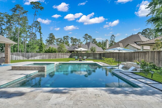 view of swimming pool featuring a patio, a fenced backyard, and a pool with connected hot tub