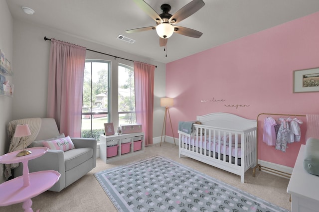bedroom featuring carpet floors, multiple windows, and a crib