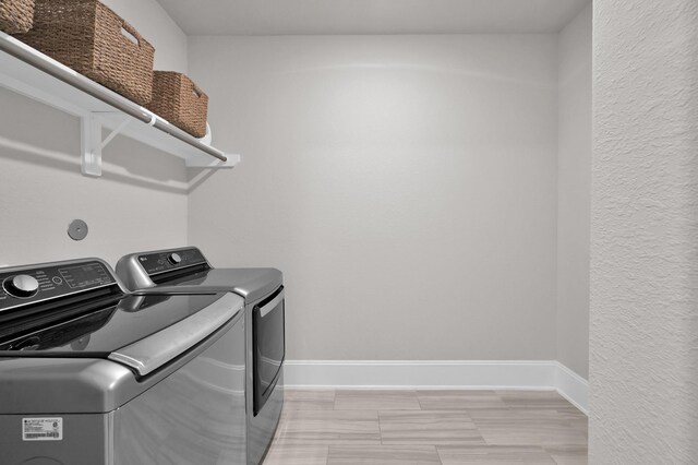 laundry area featuring washing machine and dryer and baseboards
