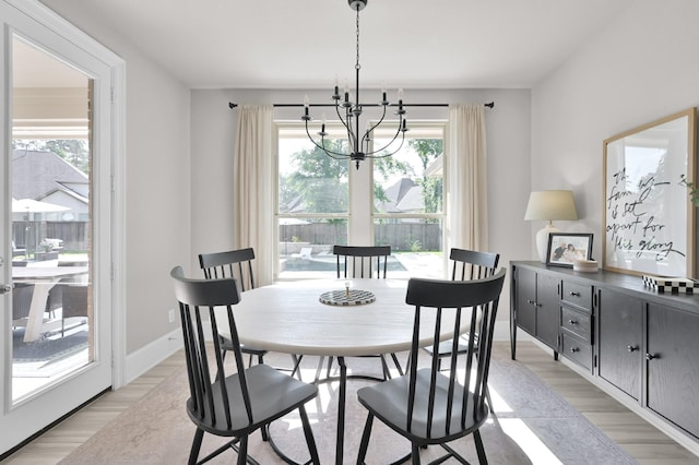 dining room featuring a chandelier, healthy amount of natural light, and light wood-type flooring