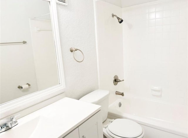 bathroom featuring toilet, vanity, shower / tub combination, and a textured wall