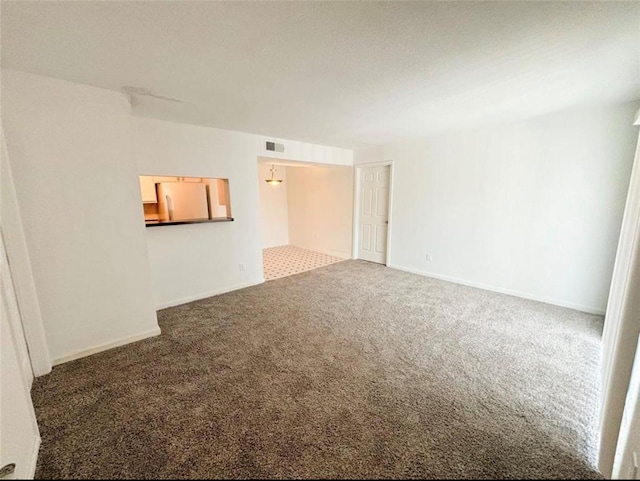 carpeted empty room featuring baseboards