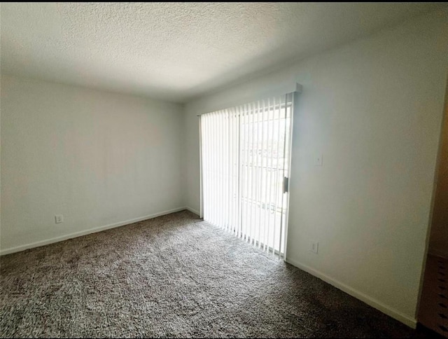 carpeted empty room with baseboards and a textured ceiling