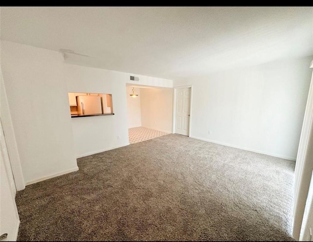 carpeted empty room featuring baseboards
