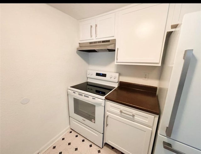 kitchen featuring white appliances, under cabinet range hood, white cabinetry, and dark countertops