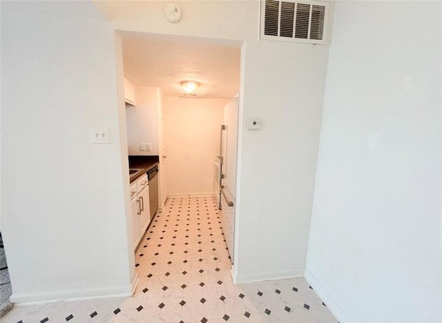 hallway featuring baseboards and light flooring