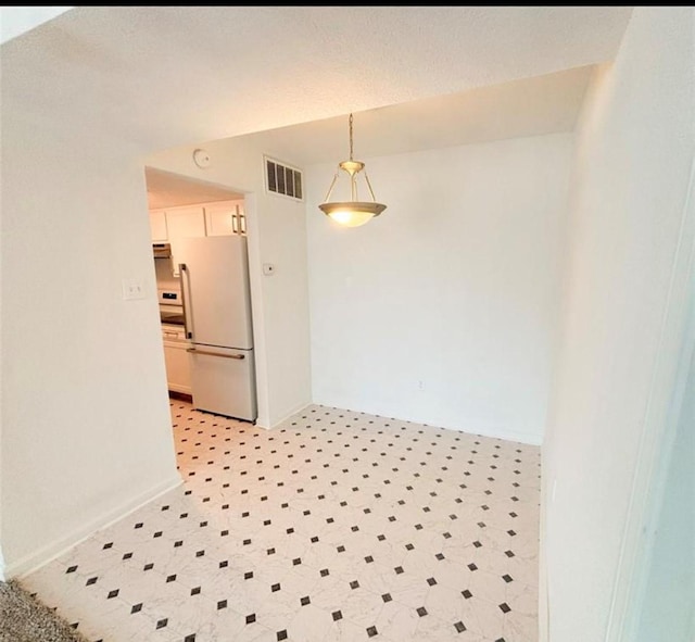 unfurnished room featuring light flooring and baseboards