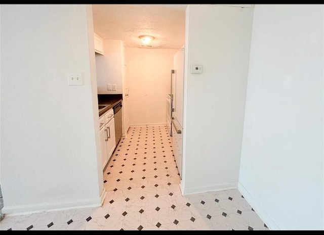 laundry area featuring light floors and baseboards