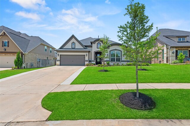 907 Falcon Hollow Ln, Pinehurst, TX 77362 - french country inspired facade featuring concrete driveway, stucco siding, and an attached garage