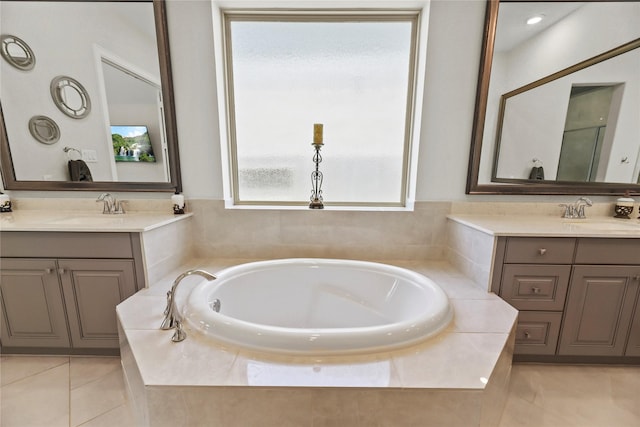 907 Falcon Hollow Ln, Pinehurst, TX 77362 - bathroom featuring two vanities, a garden tub, and tile patterned floors