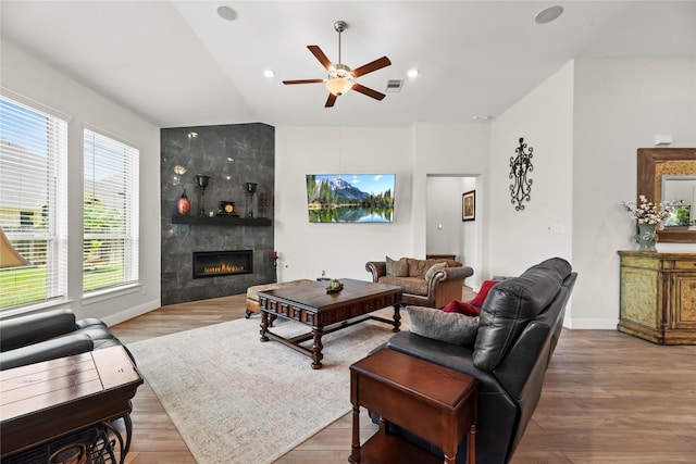 907 Falcon Hollow Ln, Pinehurst, TX 77362 - living room with a ceiling fan, a tiled fireplace, wood finished floors, lofted ceiling, and baseboards
