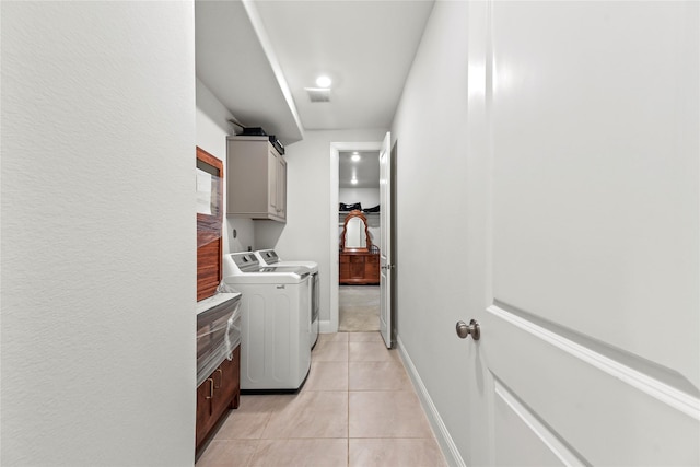 907 Falcon Hollow Ln, Pinehurst, TX 77362 - laundry area with cabinet space, washer and dryer, light tile patterned floors, and baseboards