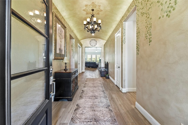 907 Falcon Hollow Ln, Pinehurst, TX 77362 - corridor with a chandelier, baseboards, light wood-style flooring, and lofted ceiling