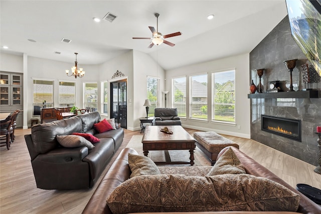 907 Falcon Hollow Ln, Pinehurst, TX 77362 - living room featuring a fireplace, a chandelier, a ceiling fan, light wood finished floors, and vaulted ceiling
