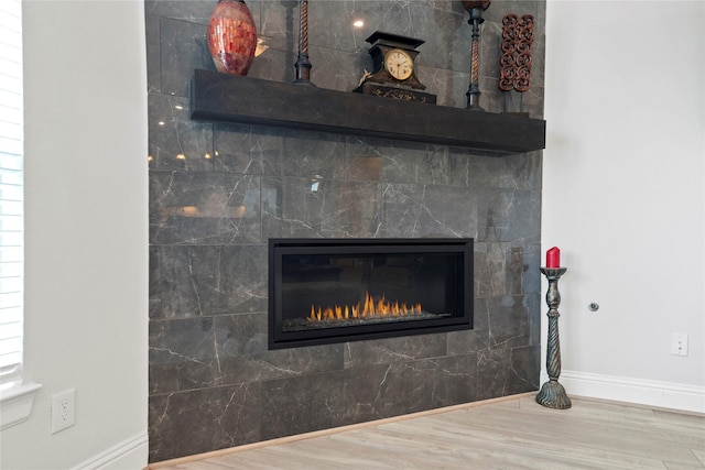 907 Falcon Hollow Ln, Pinehurst, TX 77362 - detailed view of baseboards, wood finished floors, and a glass covered fireplace