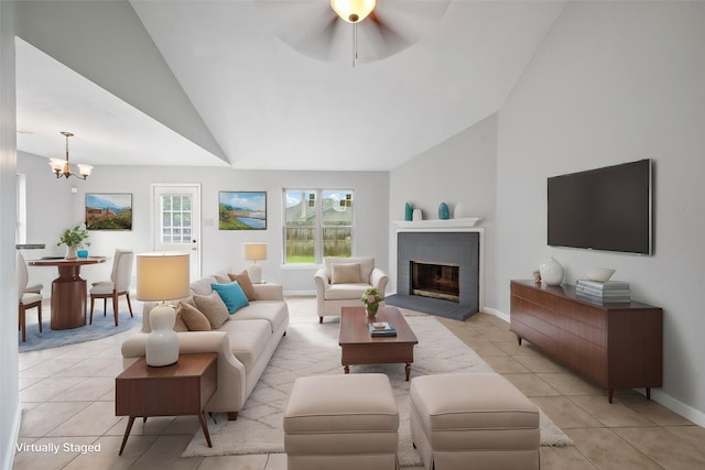 living room with vaulted ceiling, light tile patterned floors, a fireplace, baseboards, and a chandelier