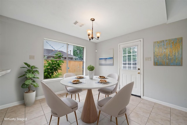 dining space with a chandelier, light tile patterned floors, and baseboards