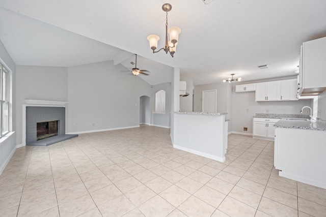 kitchen with a chandelier, light tile patterned floors, light stone countertops, and hanging light fixtures