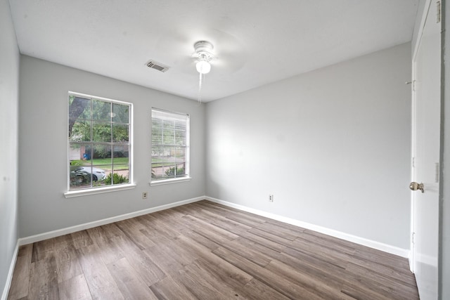 unfurnished room with wood finished floors, ceiling fan, and baseboards