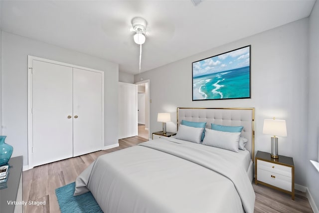 bedroom featuring wood finished floors, a closet, and baseboards