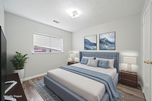 bedroom with wood finished floors and baseboards