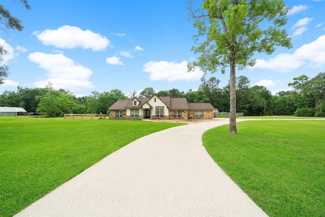 309 County Road 3665 E, Splendora, TX 77372 - tudor-style house with a front yard and stone siding