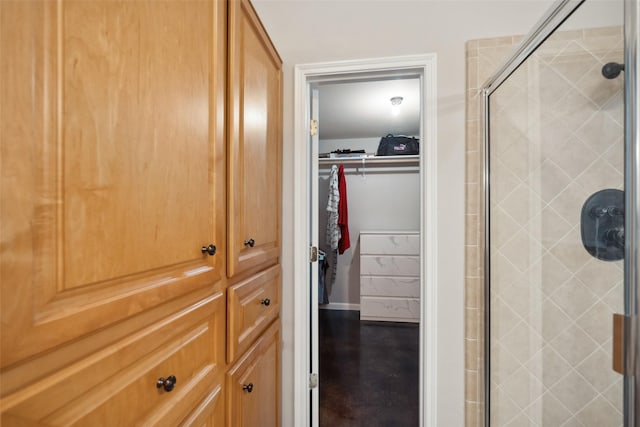 309 County Road 3665 E, Splendora, TX 77372 - bathroom with a stall shower, a walk in closet, and concrete flooring
